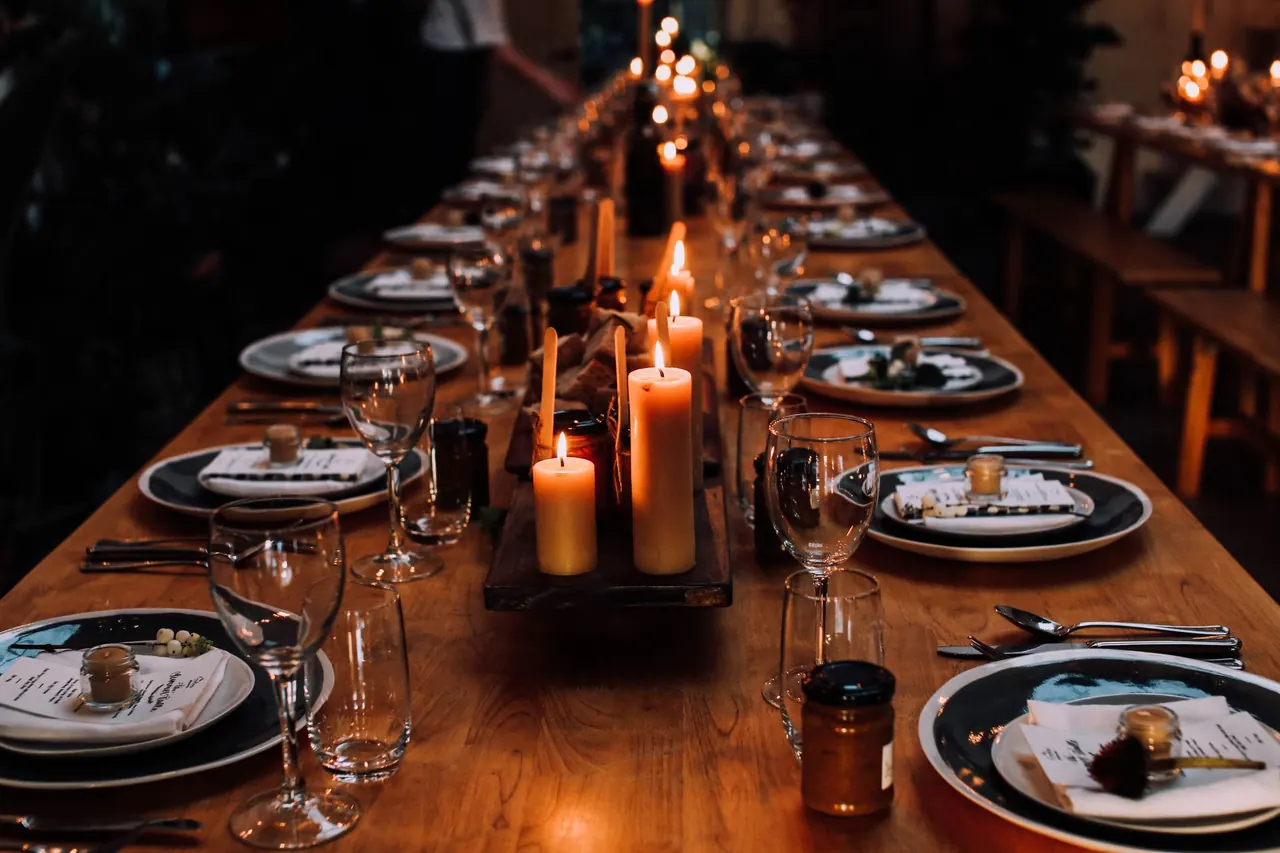 Mesa larga de banquete iluminada con velas